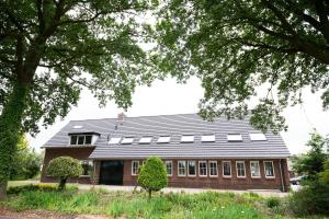una casa grande con techo negro en B&B Groot Pepersgoed en Hoevelaken