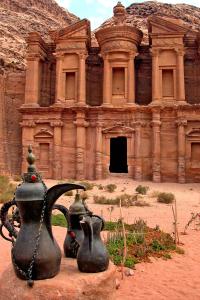 an ancient building with two vases in front of it at Petra Heritage House in Wadi Musa