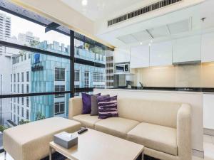 a living room with a couch and a table at Maitria Hotel Sukhumvit 18 Bangkok – A Chatrium Collection in Bangkok