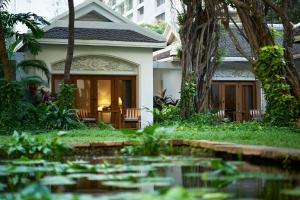 a house with a pond in front of it at Anantara Siam Bangkok Hotel in Bangkok