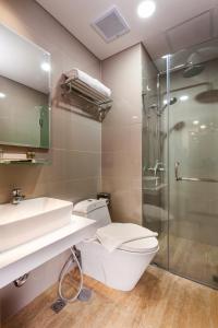 a bathroom with a toilet and a sink and a shower at Sahid Serpong in Serpong