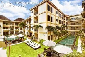 an exterior view of a hotel with a swimming pool at Kuta Town House Apartments in Kuta