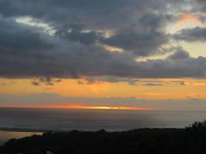 a sunset over the ocean with a cloudy sky at Palm Beach Chalets in Port Edward