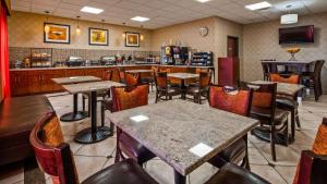 a restaurant with tables and chairs and a bar at Best Western PLUS Memorial Inn in Oklahoma City