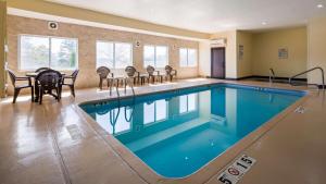 uma piscina com cadeiras e uma mesa num quarto de hotel em SureStay Plus Hotel by Best Western Blue Springs em Blue Springs