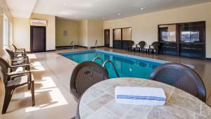 a swimming pool with a table and chairs next to it at Red Lion Inn & Suites Blue Springs in Blue Springs