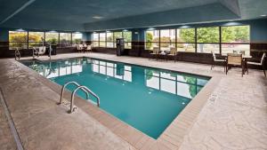 a large pool in a hotel with tables and chairs at Best Western Plus Midwest City Inn & Suites in Midwest City