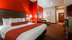 a hotel room with a bed and a red wall at Best Western PLUS Memorial Inn in Britton +10 photos