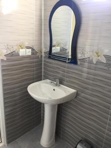 a bathroom with a sink and a mirror at Guest House Koba in Batumi