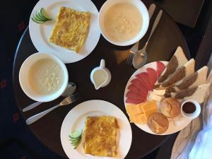 a table with plates of food and bowls of soup at Park House Taldykorgan in Taldykorgan