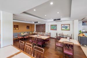 a dining room with wooden tables and chairs at JL Bangkok Hotel in Bangkok