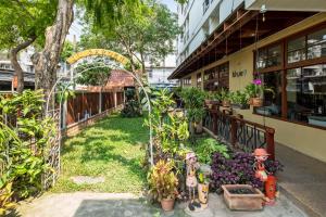 バンコクにあるJL Bangkok Hotelの植物の植えられた建物の前の庭