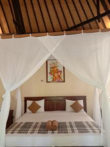 Un dormitorio con una cama con dos zapatos. en Bali Gecko Homestay, en Pemuteran