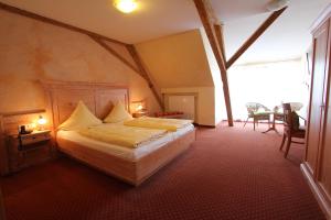 a bedroom with a bed in a room with a window at Weinhotel / Gasthaus zur Sonne in Ihringen
