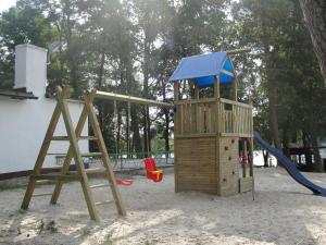 a wooden playground with a slide and a play structure at Zielony Cypel in Lubniewice