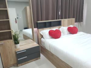 a bedroom with two beds with red hearts on the pillows at iResidence hotel in Ban Khlong Nung