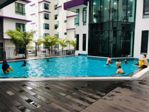 a group of people in a swimming pool in a building at Homie The Heights Residence 6-8 Pax 6-8人 in Ayer Keroh