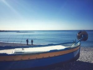 a boat on the beach with two men fishing at Villa du Cros in Cagnes-sur-Mer