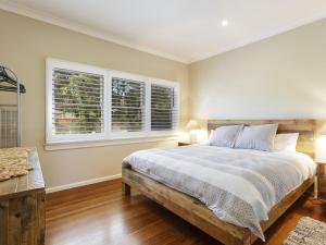 a bedroom with a bed and two windows at Summer Cottage in Hawks Nest
