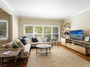 a living room with a couch and a tv at Summer Cottage in Hawks Nest