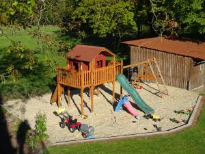 um parque infantil com escorrega e uma casa de brincar em Ramakers Hof em Kirchlinteln