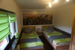 2 camas en una habitación con un cuadro en la pared en FerienhausTeube en Kurort Gohrisch