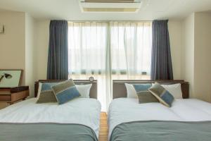 大阪Minn Umeda North的有窗户的房间里有两张床