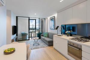 墨爾本的住宿－想像燈塔公寓式酒店，厨房以及带沙发和桌子的客厅。