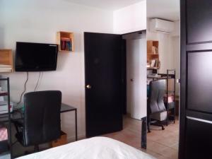 カンヌにあるLa Baronne Apartmentの黒いドア、デスク、椅子が備わるベッドルーム1室が備わります。