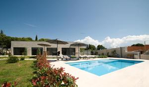 Selca的住宿－Villa Pietra，后院带遮阳伞的游泳池