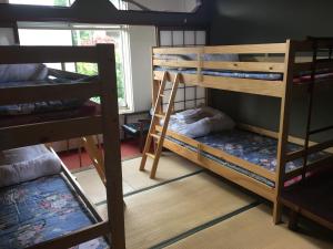 a room with two bunk beds and a window at Towadako Hostel in Towada