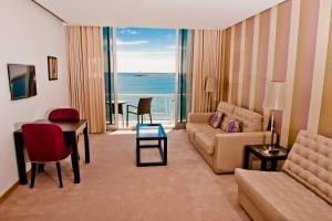 uma sala de estar com um sofá e uma mesa em Atlantida Mar Hotel em Praia da Vitória