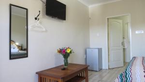 a room with a vase of flowers on a table at Karoo-Koppie in Colesberg