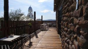 a wooden walkway with a clock tower in the background at Karoo-Koppie in Colesberg