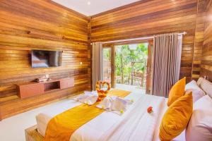 1 Schlafzimmer mit 2 Betten und einem TV an der Wand in der Unterkunft Dinatah Lembongan Villas in Nusa Lembongan