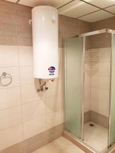 een douche met een glazen deur in de badkamer bij Apartment By The Sea in Pomorie