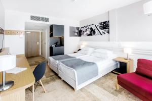 1 dormitorio con cama, escritorio y sofá en Hotel Platan en Gdansk