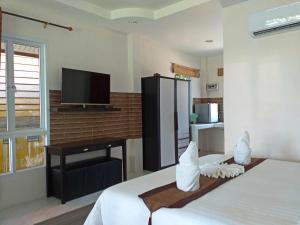 Un dormitorio con una cama, un escritorio y un televisor. en The Ford SunSet Beach Resort, en Wok Tum