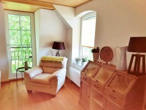 a living room with a chair and two windows at FEWO 1 in Wiek auf Rügen