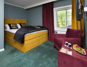 a bedroom with a bed and a couch and a chair at Arendal Herregaard Spa & Resort in Arendal