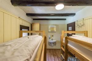 En eller flere senge i et værelse på Chalet Hostel Murka