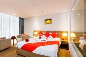 Pokój hotelowy z dużym łóżkiem z czerwonymi poduszkami w obiekcie Maple Leaf Hotel & Apartment w mieście Nha Trang