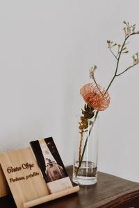 a table with a book and a vase with a flower at Centro SPA Atostogų namai in Birštonas