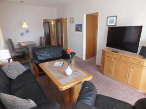 a living room with a couch and a table with a television at Ferienwohnungen Hüning in Grömitz