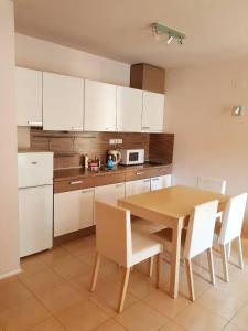 - une cuisine avec une table en bois et des placards blancs dans l'établissement Apartment By The Sea, à Pomorie