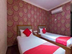 Tempat tidur dalam kamar di Super OYO 998 Queen City Hotel