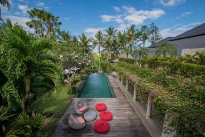 un complejo con piscina y pasarela de madera en Villa Sally, en Canggu