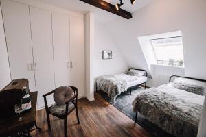 a bedroom with two beds and a chair and a table at Ferienwohnung Sonnenschein in Lengerich