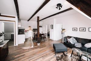 a living room with white walls and a black couch at Ferienwohnung Sonnenschein in Lengerich