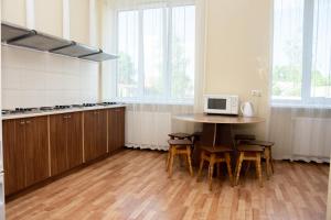 a kitchen with a table with chairs and a microwave at Monada Hotel & Hostel in Uzhhorod